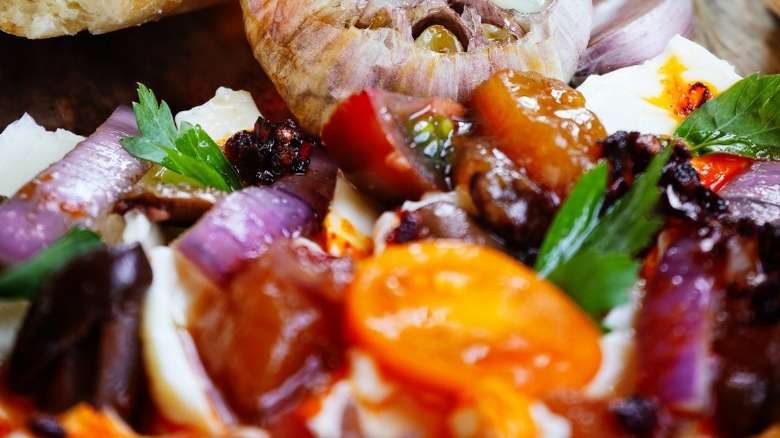 Butter board with roasted garlic, tomatoes, and herbs