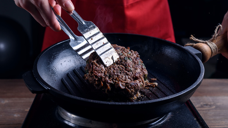 cook flipping steak in pan