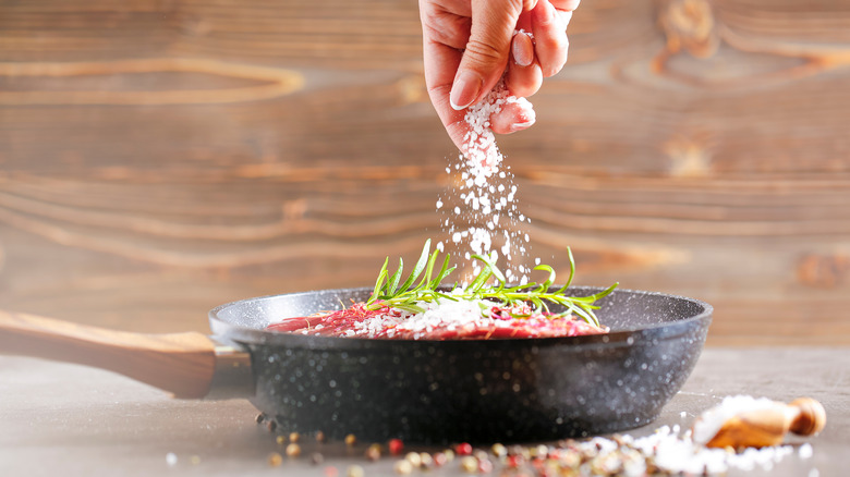 seasoning flank steak in skillet