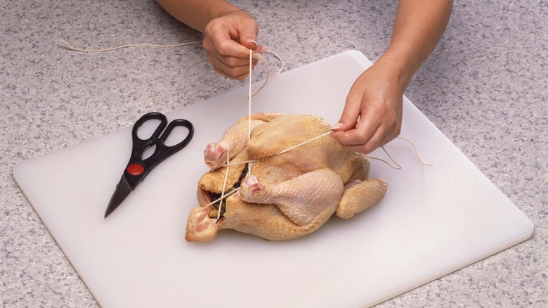 hands trussing a chicken