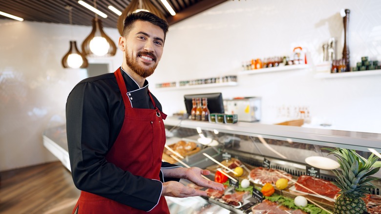 Smiling butcher and display case