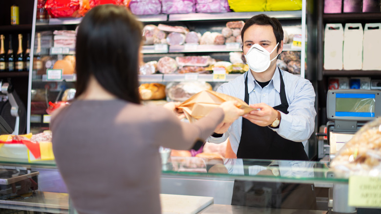 Butcher handing wrapped meat