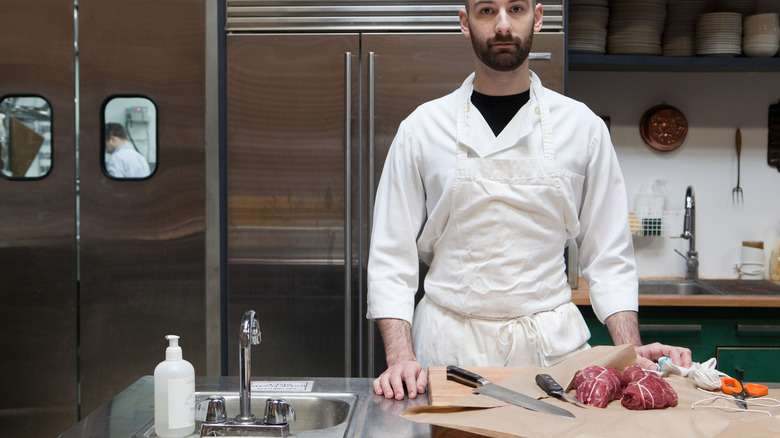 Butcher prepping small cuts of meat on counter