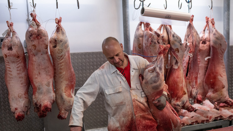 Butcher preparing to break down pig carcass