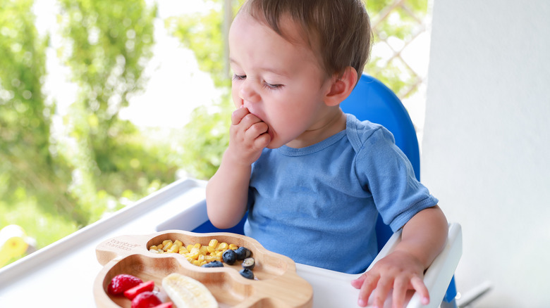 A toddler sampling food