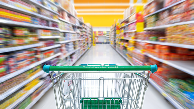 Grocery cart in blurred aisle