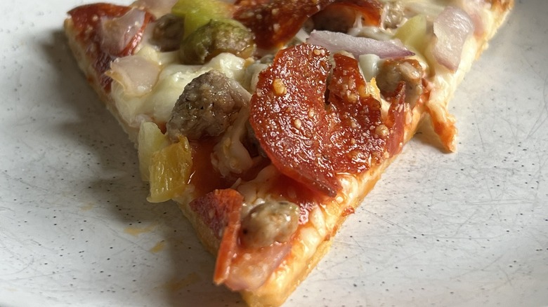 A slice of Tombstone "The Primo" Tavern Style Pizza