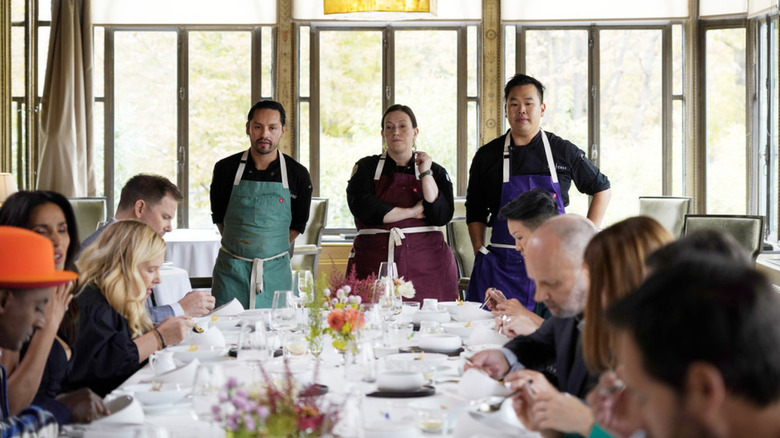 Top Chef top 3 looking over dining table