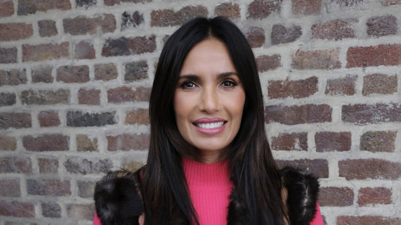 Padma Lakshmi smiling with brick background