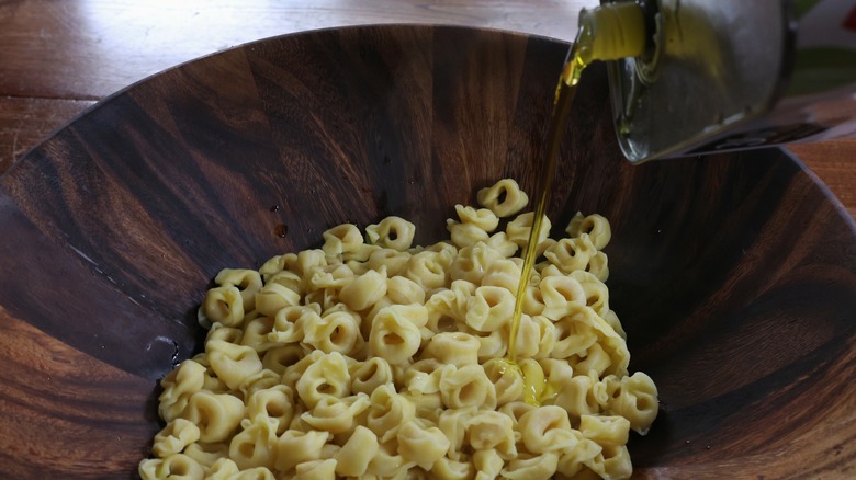 drizzling olive oil over tortellini