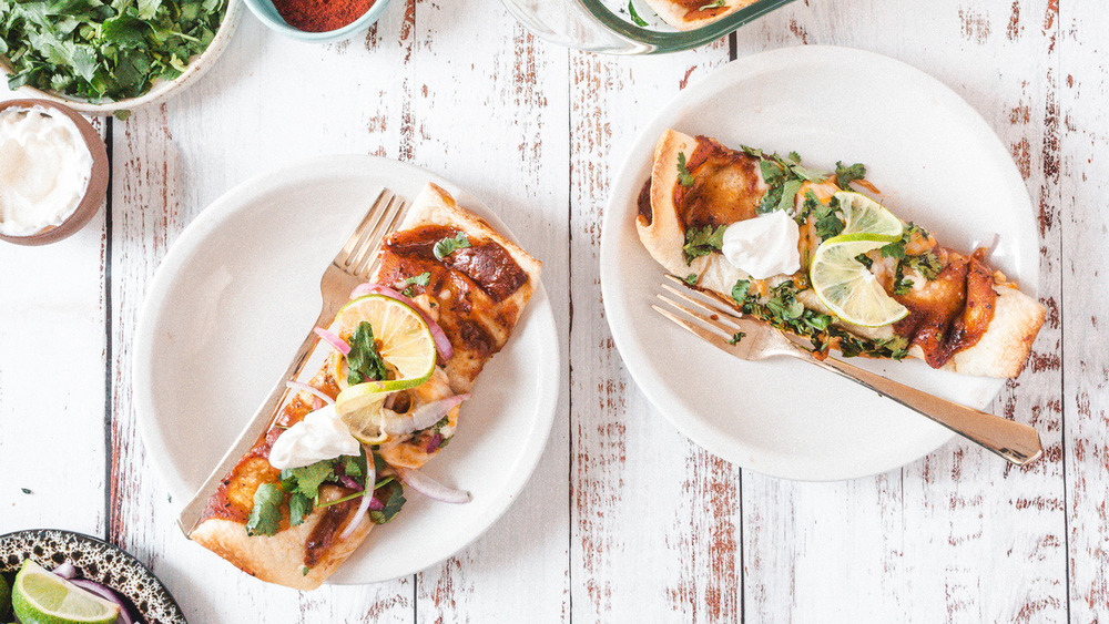 baked chicken enchiladas topped with sauce and cilantro