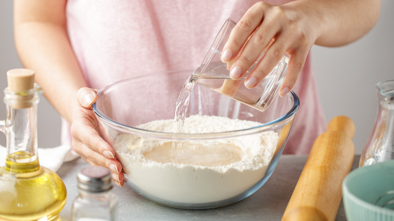 A woman mixing masa