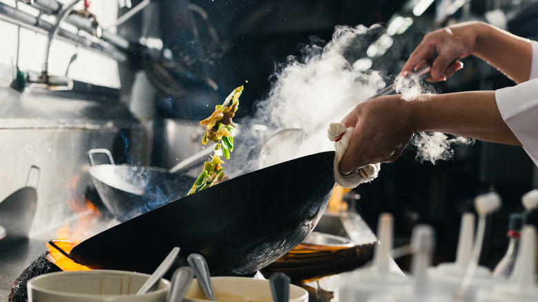 Stir frying vegetables in black wok