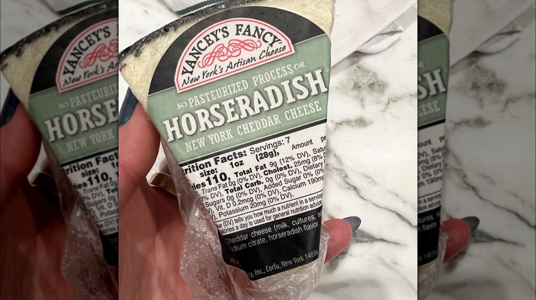 hand holding Yancey's Fancy Horseradish Cheddar Cheese