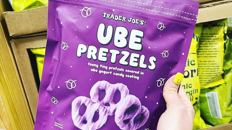 Person's hand holding purple bag of ube pretzels at Trader Joe's