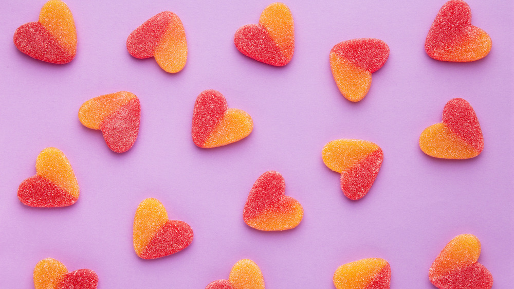 Heart-shaped gummies on purple background