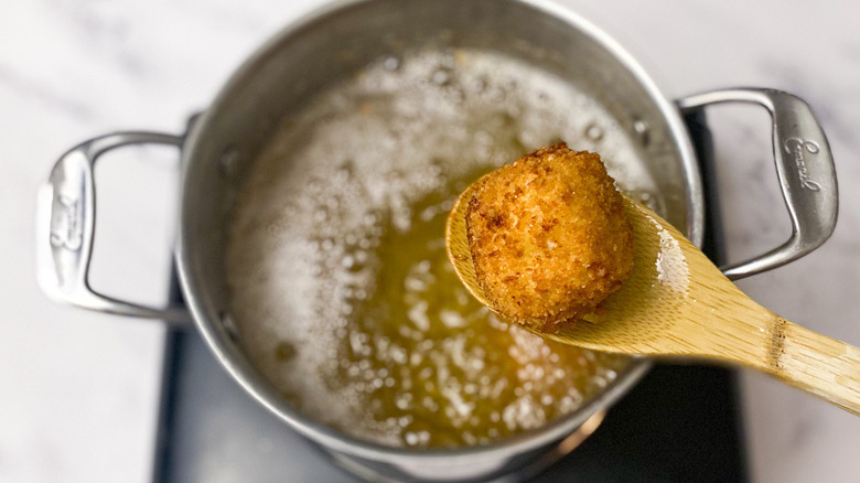 Arancini with pot of oil