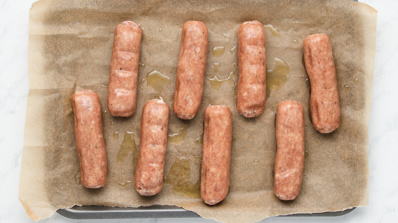 oiled sausages on baking pan