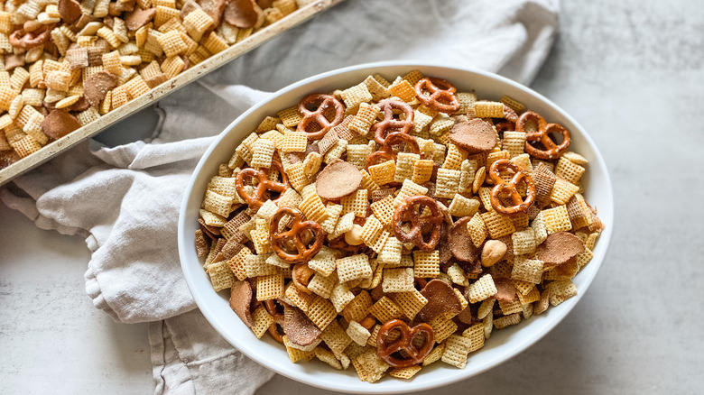 Bowl and tray of Chex mix with dishtowel