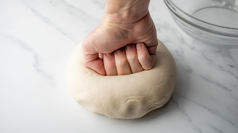 hand punching down Traditional German brötchen dough