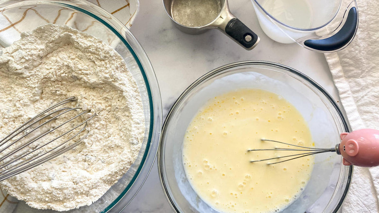 bowl of dry ingredients, a measuring cup, measuring cup of buttermilk, bowl of wet ingredients