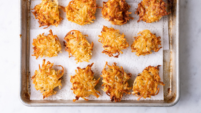 fried latkes on a baking sheet