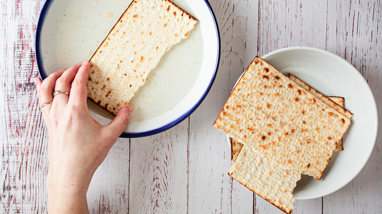 hand soaking matzo in water