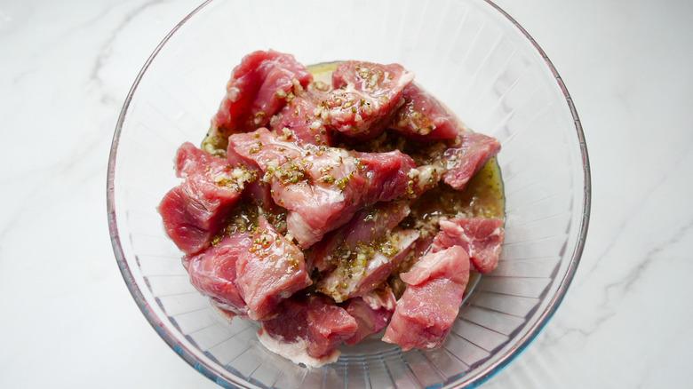 Pork marinating in glass bowl