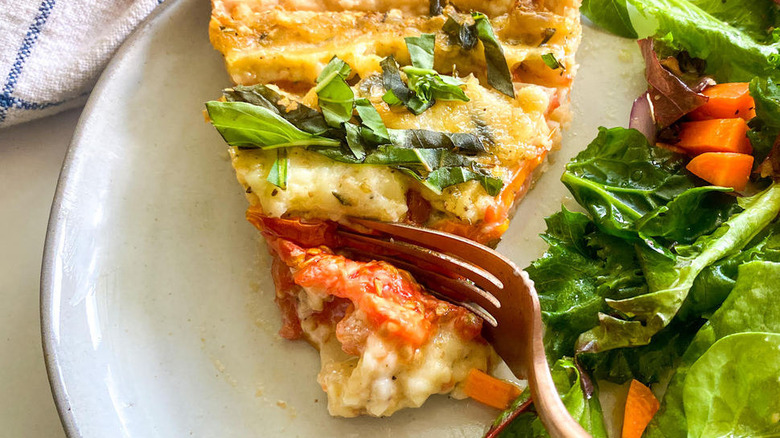 fork cutting into tomato pie