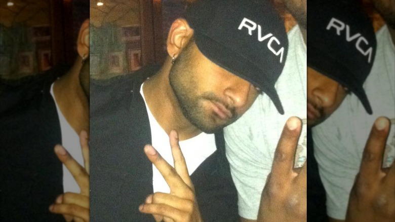 Ashish Alfred in baseball cap giving a peace sign