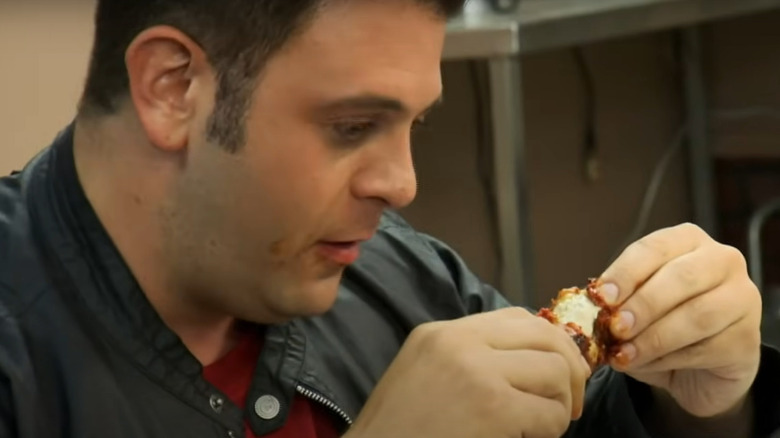 Adam Richman eating a chicken wing