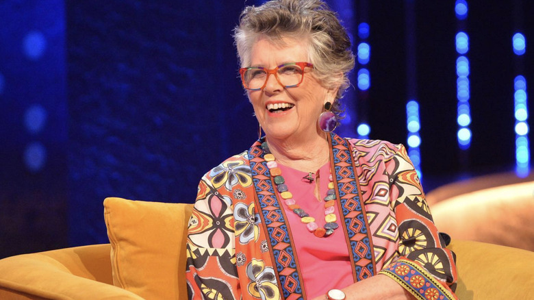 Prue Leith smiles on yellow couch