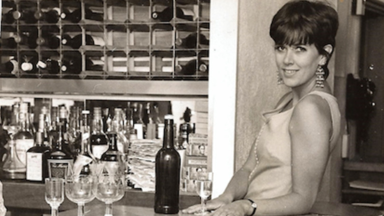 Young Prue Leith poses by bar