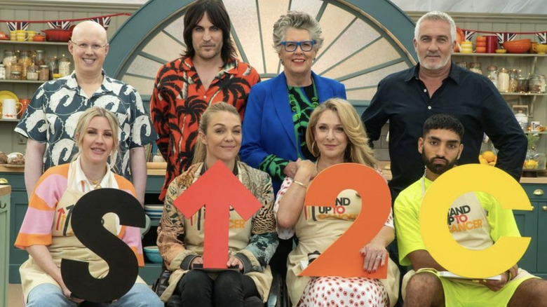 Prue Leith and Great British Bake Off cast hold Stand Up To Cancer sign