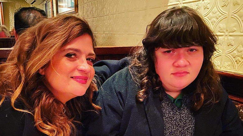 Chef Alex Guarnaschelli posing in a booth with daughter Ava