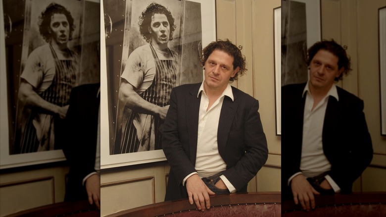 Marco Pierre White stands beside his portrait