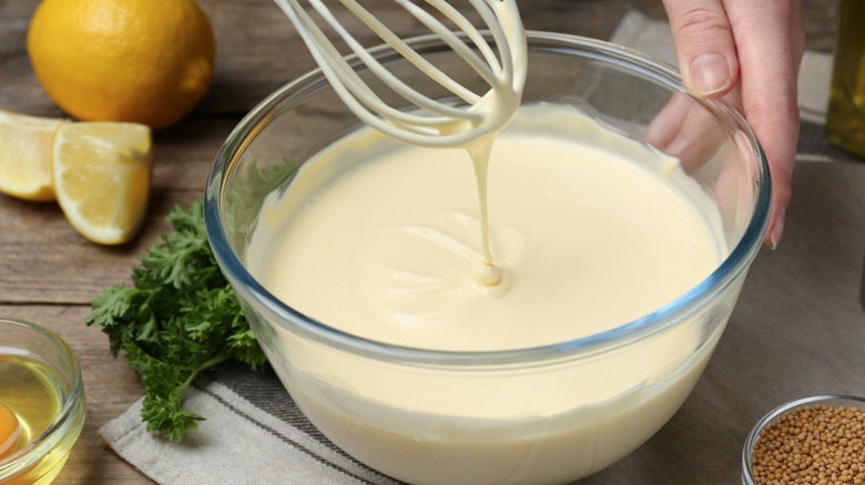 Person whisking a bowl of mayonnaise