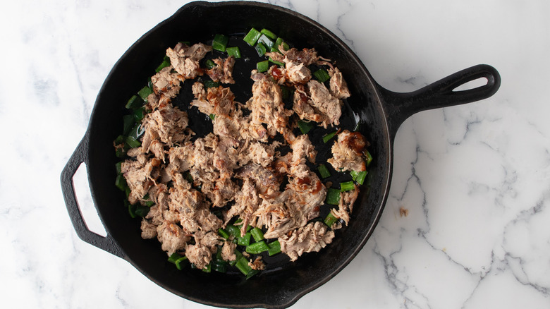 sauteing pork with peppers in skillet