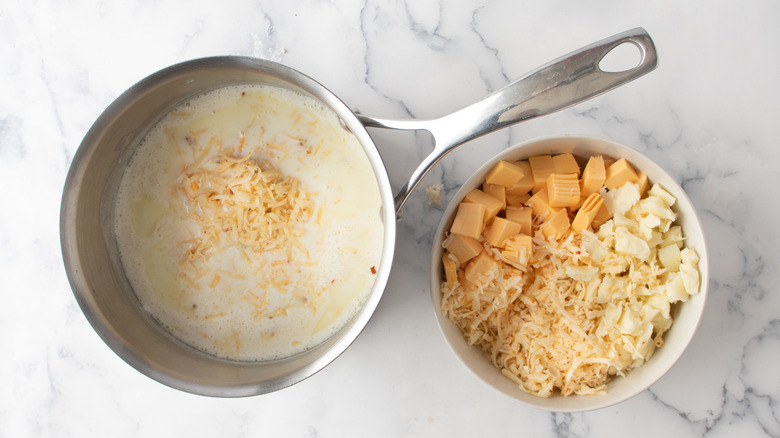 adding shredded cheese to saucepan