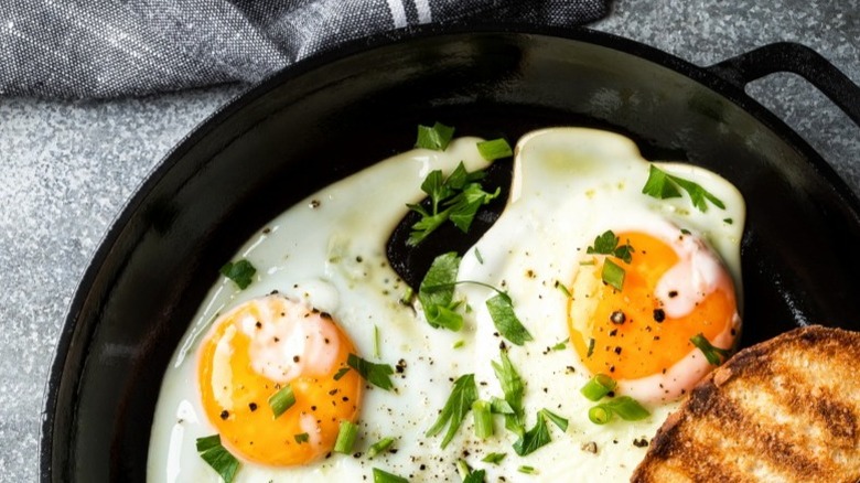 Fried eggs in a cast iron skillet with toast