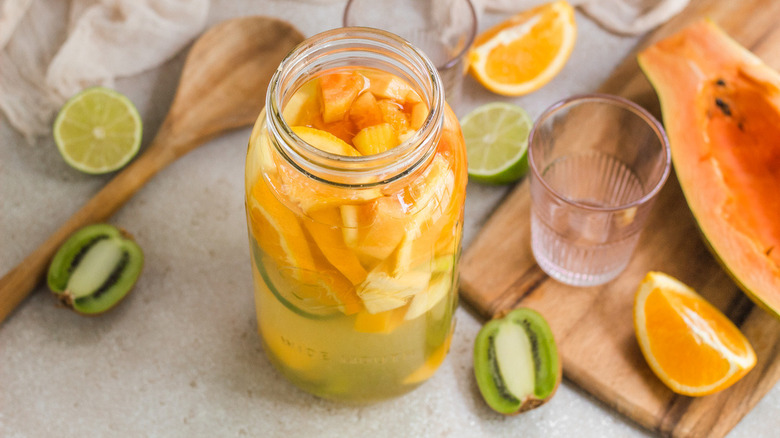 Glass jar of sangria with assorted fruits