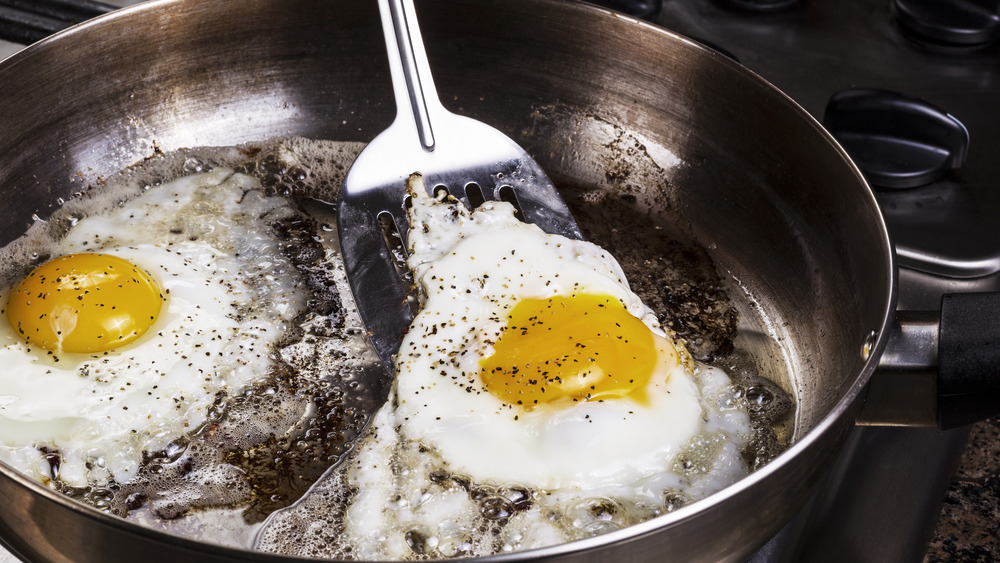 Fried eggs cooking in bacon grease