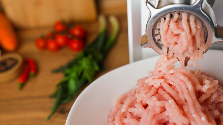 Turkey meat going through grinder