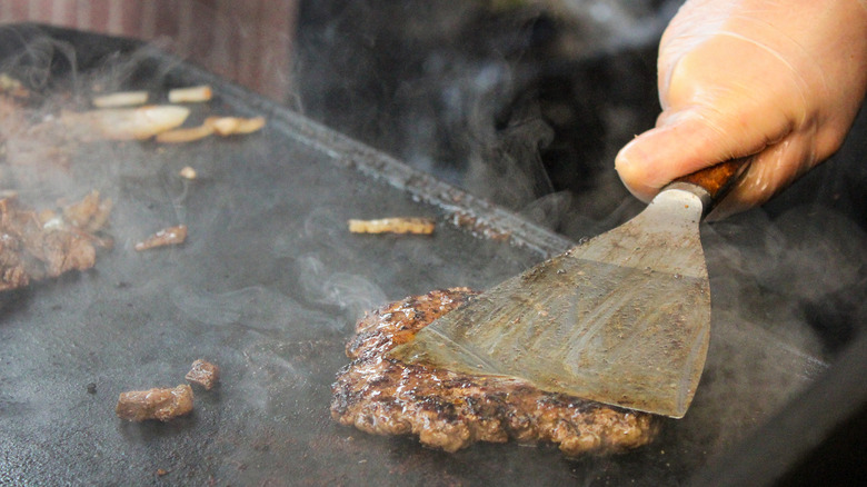 Hand with spatula smashing down