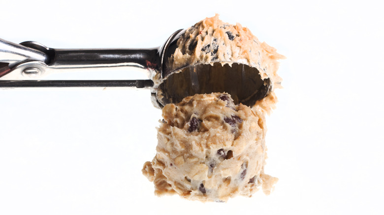 Cookie scoop with ball of chocolate chip cookie dough.