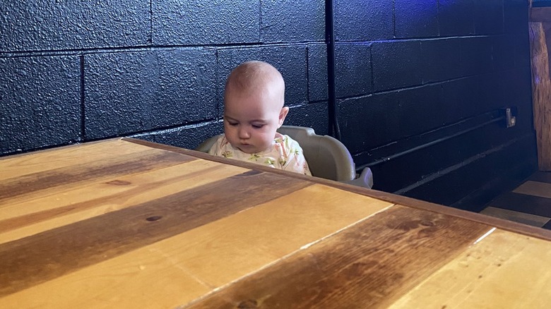 Baby Goldman sitting in a high chair waiting for BBQ