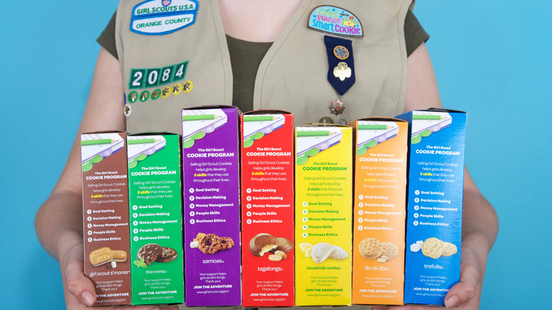 Girl Scout holding boxes of cookies