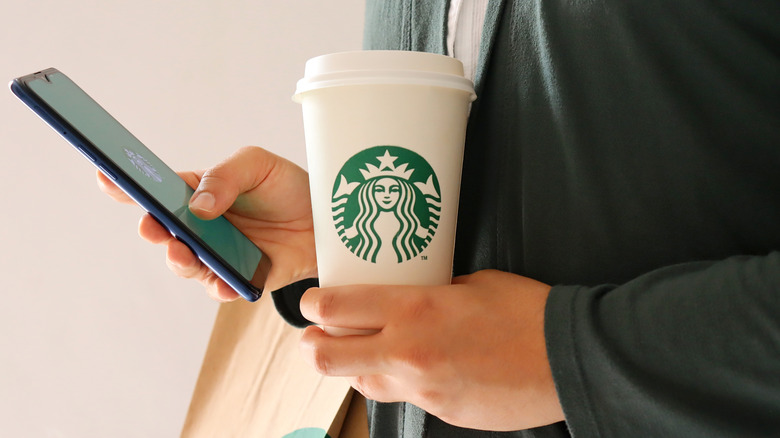 Person holding Starbucks cup