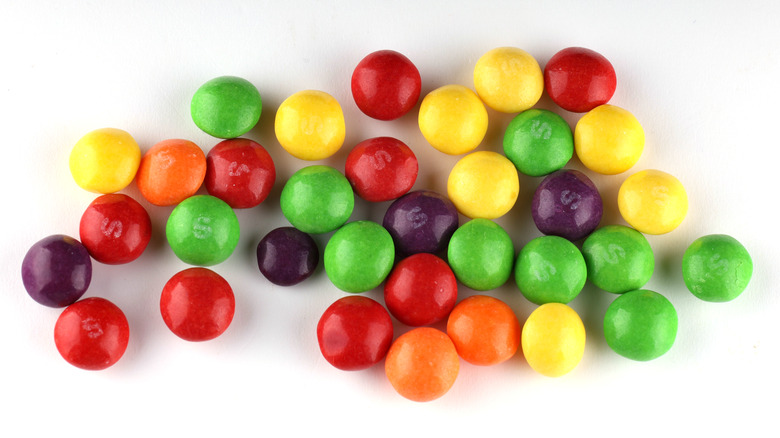 Loose Skittles candies on white background