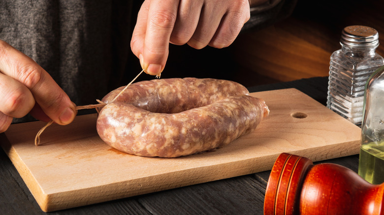 Person tying sausage